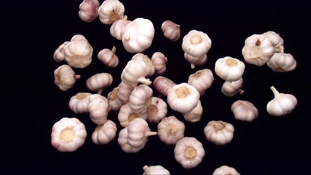 garlic bouncing on black background in slow motion