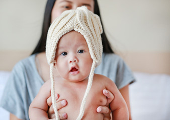 Adorable infant baby boy wear some knit clothes with mother holding.