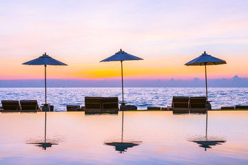 Umbrella and chair around swimming pool in resort hotel for leisure travel and vacation