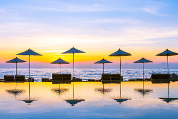 Umbrella and chair around swimming pool in resort hotel for leisure travel and vacation