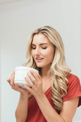 Woman drinking coffee, tea or soup from cup