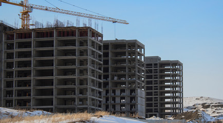 Buildings under construction. Kazakhstan (Ust-Kamenogorsk). Residential buildings. Construction crane. Cranes and buildings. New residential area. Construction site. Concrete frame. Housing estate