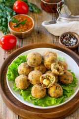 Arancini. Italian Rice Balls with Mozzarella and Sun-dried tomatoes, with tomato sauce on wooden table.