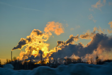 air pollution from multiple pipes at sunset in winter