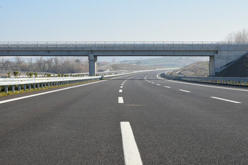 Construction of newly finished, empty highway. - obrazy, fototapety, plakaty