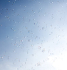 Soap bubbles fly in the blue sky