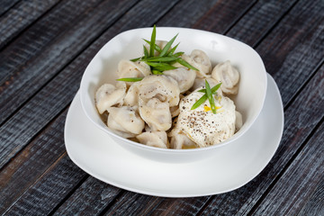 real, delicious, Russian dumplings on the table, with fresh herbs and spices, for cooking design.