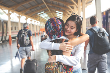 Two women hugging each other at the train station Tourism concept