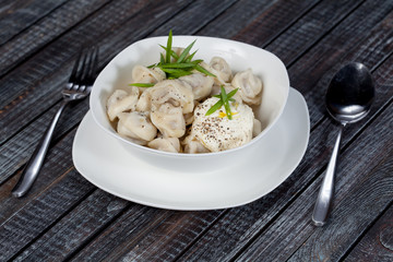 real, delicious, Russian dumplings on the table, with fresh herbs and spices, for cooking design.