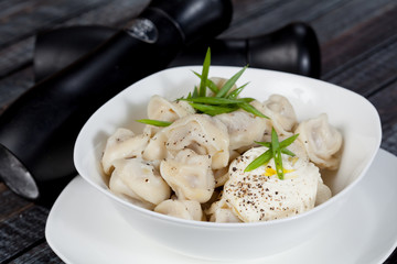 real, delicious, Russian dumplings on the table, with fresh herbs and spices, for cooking design.