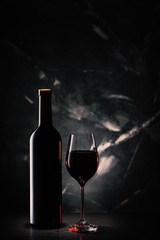 Silhouette of bottle and glasses of red wine on dark marble background