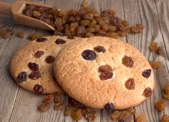 Oatmeal cookies with raisins,  on a dark wooden background with a wooden spoon