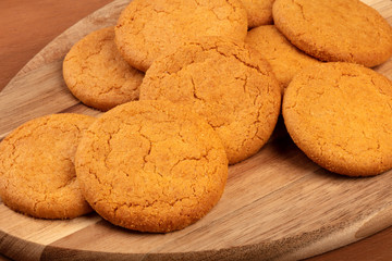 A closeup photo of gingersnaps on a rustic background