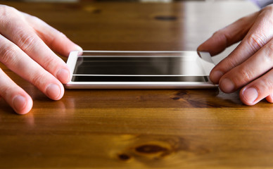 Man hands fingers hold smartphone screen protective covering glass on top of smartphone, about to install the protection glass. Protecting from scattering, scratches and cracks concept.