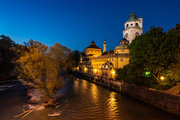 München Müllersches Volksbad bei Nacht in blauer Stunde mit Isar im Vordergrund