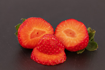 funny strawberry face on black background, happy smiling fruit