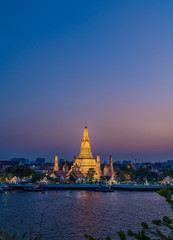 Night photo illuminated old Wat Arun Ratchawararam Ratchawaramahawihan or Wat Arun "Temple of Dawn" - Buddhist temple in Bangkok Yai district, Thailand, on the Thonburi bank of Chao Phraya River