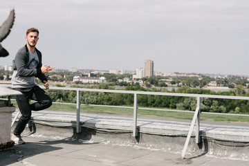 A man runs on the roof of the building. Advertising menswear.