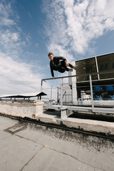 A man practices parkour, runs and jumps over obstacles