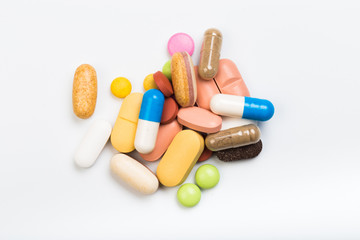 set of multi-colored tablets and capsules on a white background