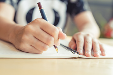 female hands with pen writing on notebook - Image