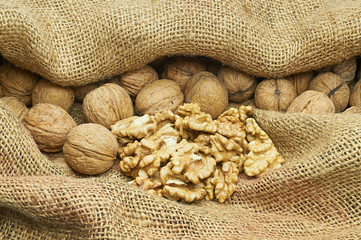 Walnuts on natural burlap, walnut kernels in a wicker basket, nutty background