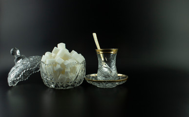 crystal glasses on the black background    cube sugar ,spoon
