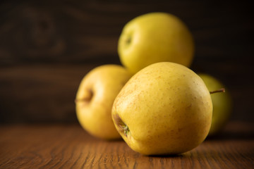 Yellow apple on the wooden vintage background