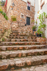 Fototapeta na wymiar Spain, Tossa de Mar, cobbled street in medieval Old Town - Vila Vella