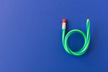 Flexible pencil . Isolated on blue background. Bending pencil.