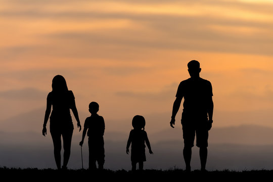 silhouette of a happy family with children on sunset time