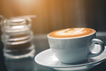 Latte coffee or coffe on wood table at cafe in the morning 