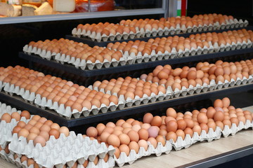 Eggs for sale at a Dutch market place, with some cheese in the background