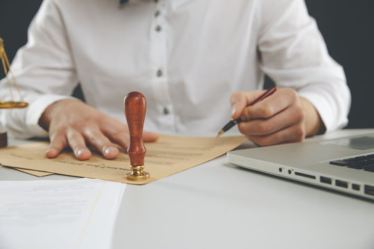 Close up on man notary public hand ink stamping the document. Notary public concept