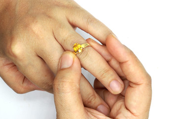 woman hand putting a wedding ring isolated on black background.