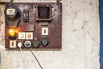 The old cabinets with wiring and piping of the electrical system control in small factory for automation works