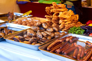 Baked potatoes, mushrooms and sausages at the food fair