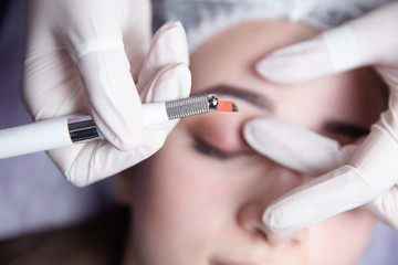 Permanent Makeup For Eyebrows. Microblading brow. Beautician Doing Eyebrow Tattooing For Female...