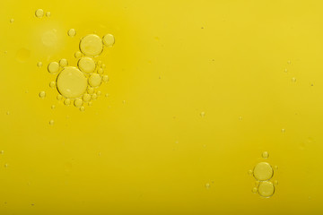 Abstract blurred gentle background. Fluid texture with circles and bubbles of yellow color. Cropped shot, macro, horizontal, nobody, free space for text.