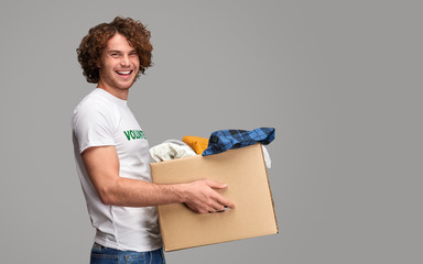 Smiling volunteer carrying donations