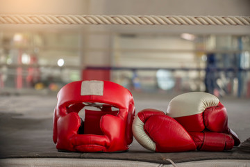 Boxing Headquard and leather mitt glove placed on canvas of ring in camp of training boxer.Equipments for protection during heavy sparring sessions,Used for Muay Thai, Kick Boxing and MMA Training