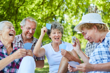 Senioren Freunde spielen Karten im Garten