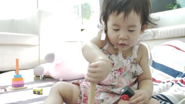 Happy asian girl playing alone on sofa at home . 4K Slow motion of beautiful female child .