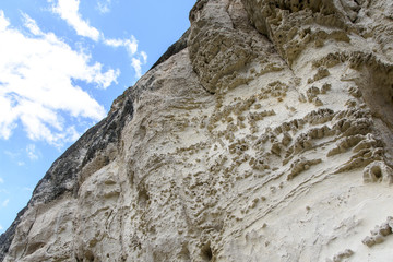 high rocky mountains against the blue sky and white clouds in the desert  