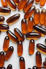 Pile of scattered capsules with medication on white background