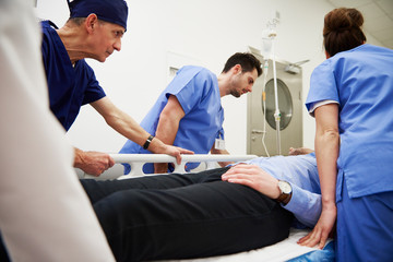 Side view of doctors running to the operating room