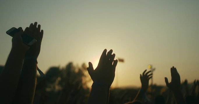 People having fun and clapping hands at the music concert in slow motion.