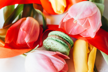 Delicious macaroon and bright tulips, sweet dessert