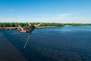man jumps from the bridge tied to the rope