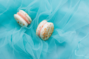 Composition of delicious macaroons on blue textile